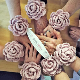 Mani intrecciate e bracciale rosa